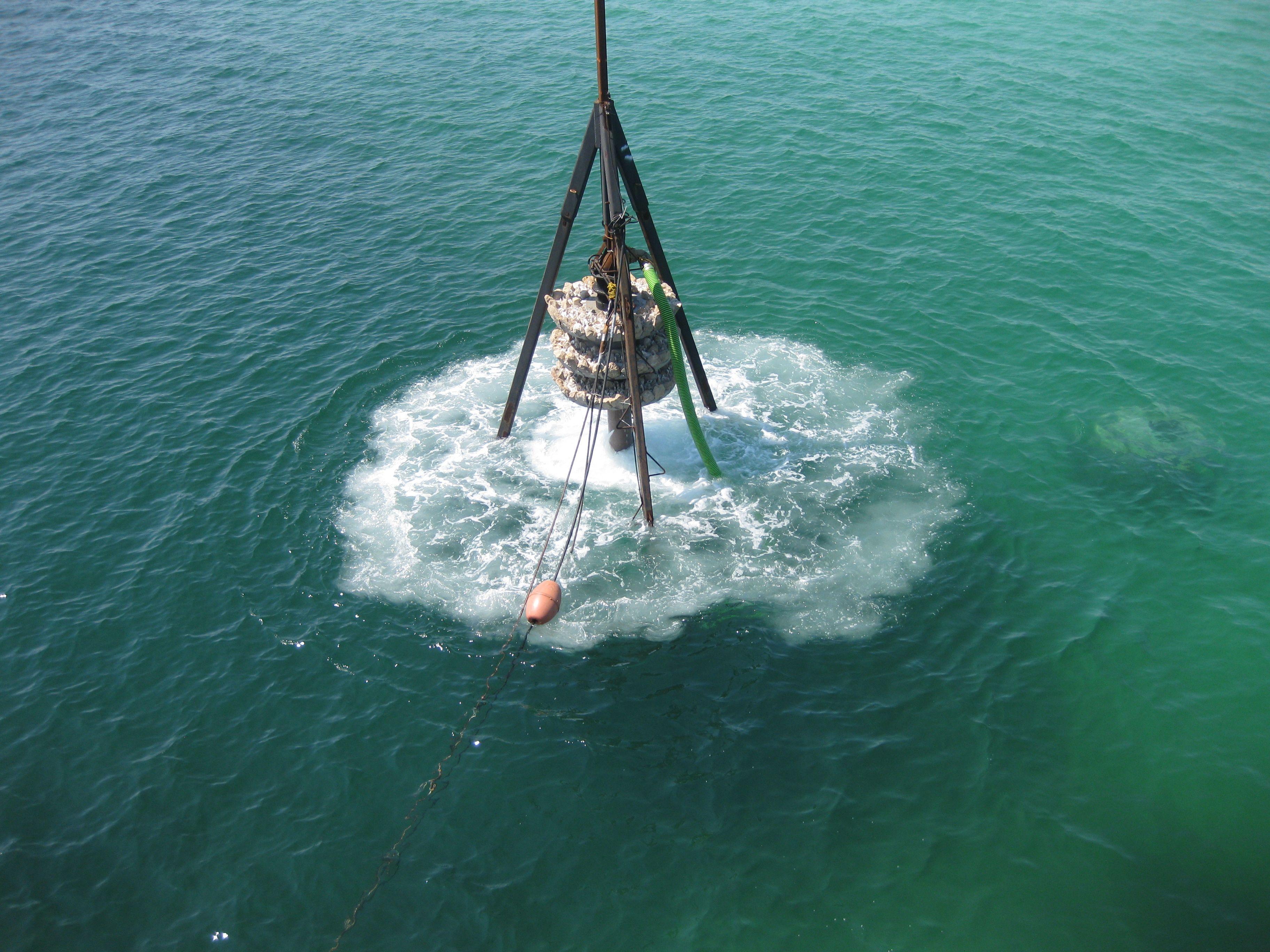 Crane rigging entering the water during artificial reef deployment