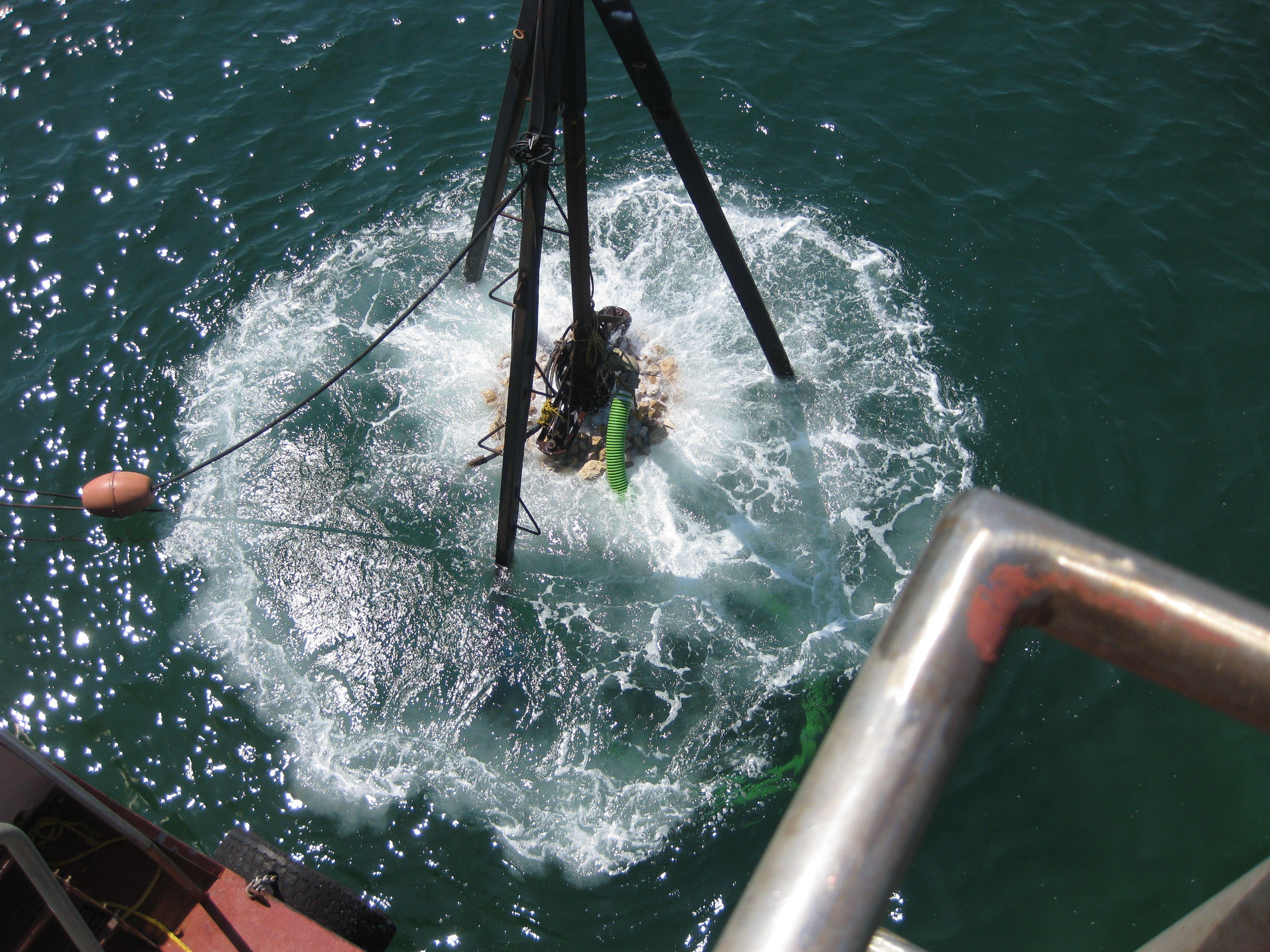 Water splashing around crane rigging during artificial reef deployment