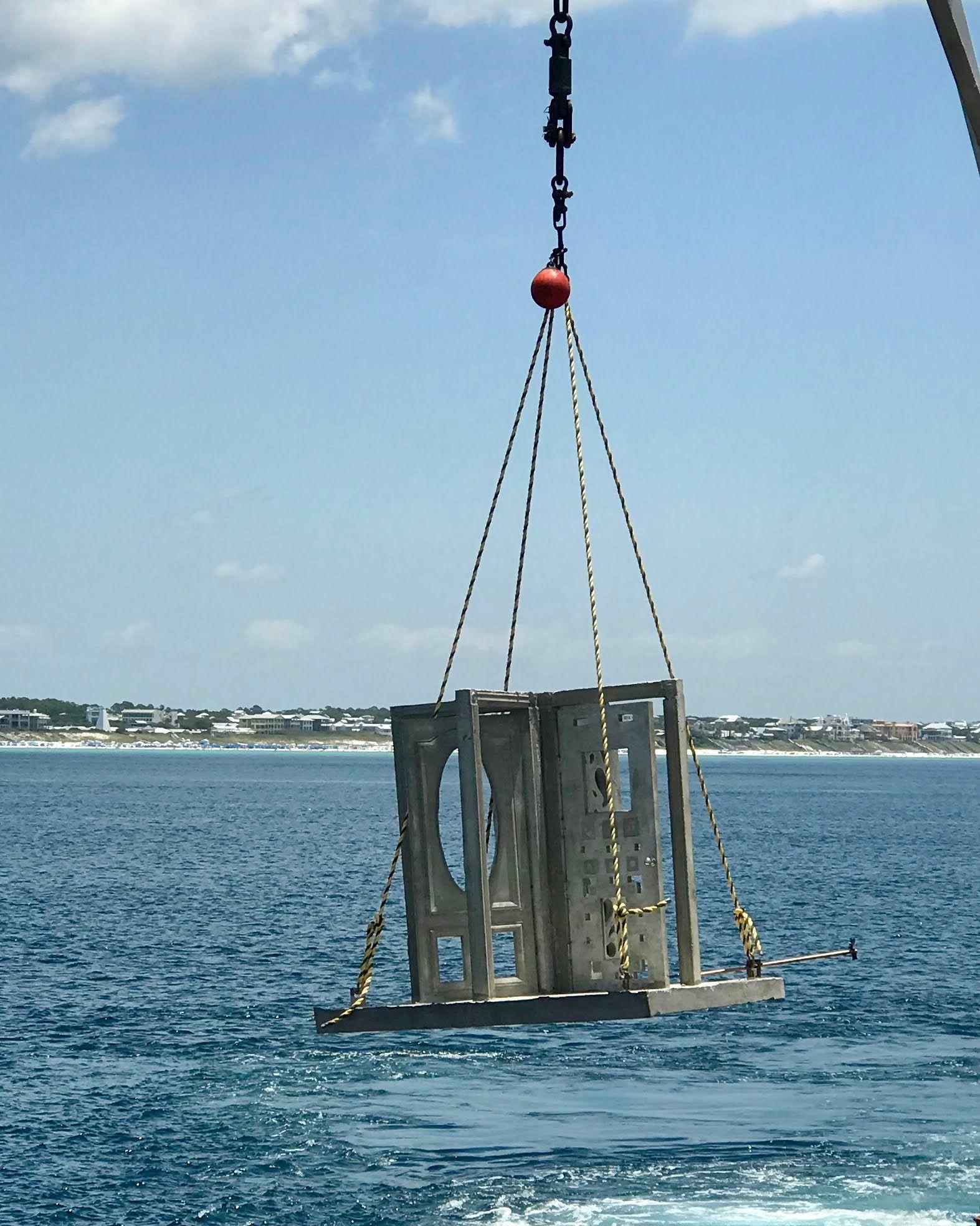 Rectangular cage-style artificial reef structure suspended above the water