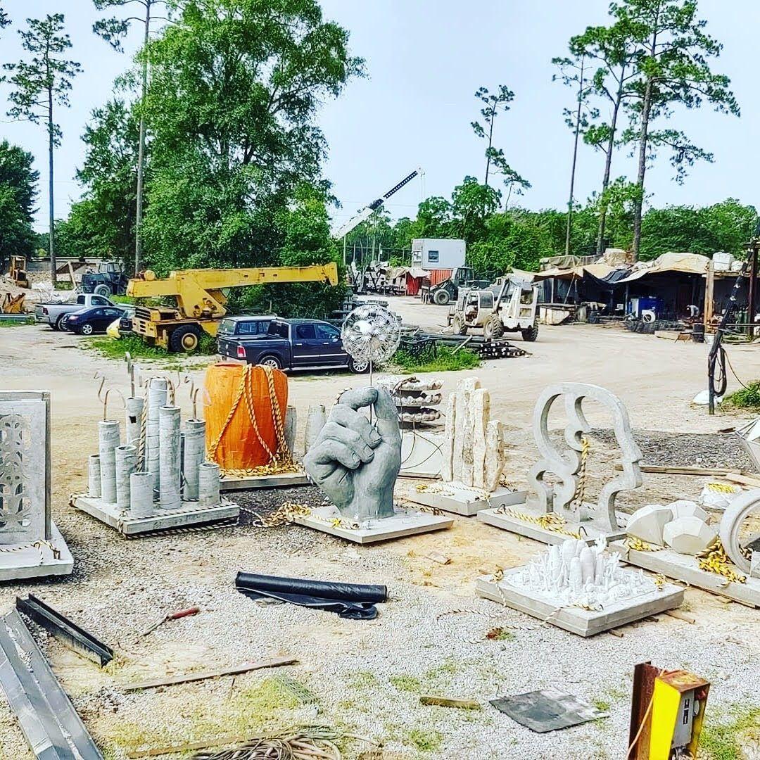Concrete artificial reef modules and equipment in an outdoor fabrication yard